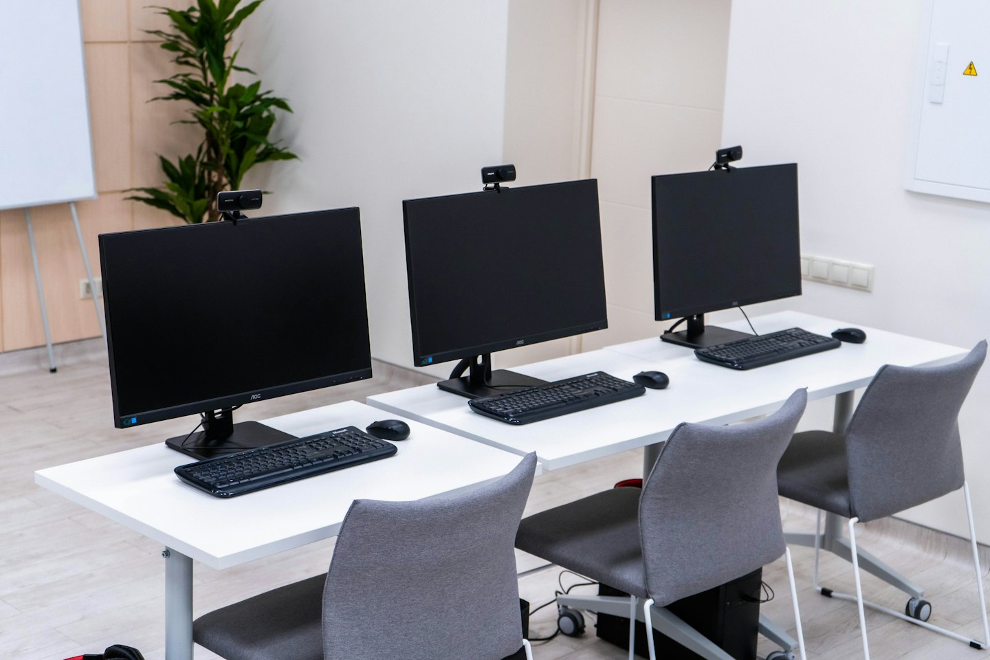 Three modern computer workstations set up side-by-side in an office.